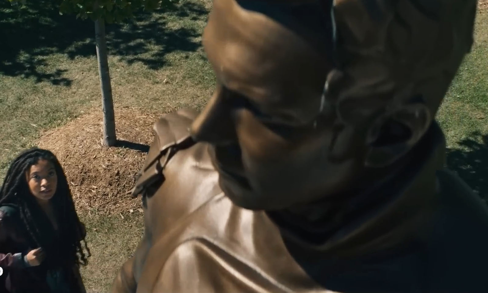 Personagem principal olhando para a estátua da universidade em cena do primeiro trailer de Gen V.
